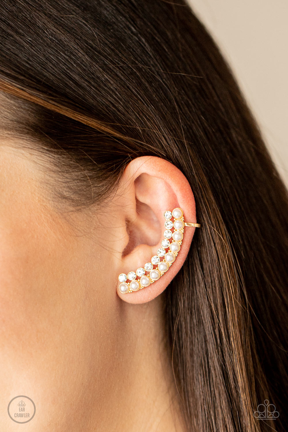 Doubled Down On Dazzle Gold Ear Crawler Earring - Paparazzi Accessories  Featuring classic gold fittings, two rows of dainty white pearls and glassy white rhinestones arch into a timeless statement piece. Earring attaches to a standard post earring. Features a clip-on fitting at the top for a secure fit.  Sold as one pair of ear crawlers.