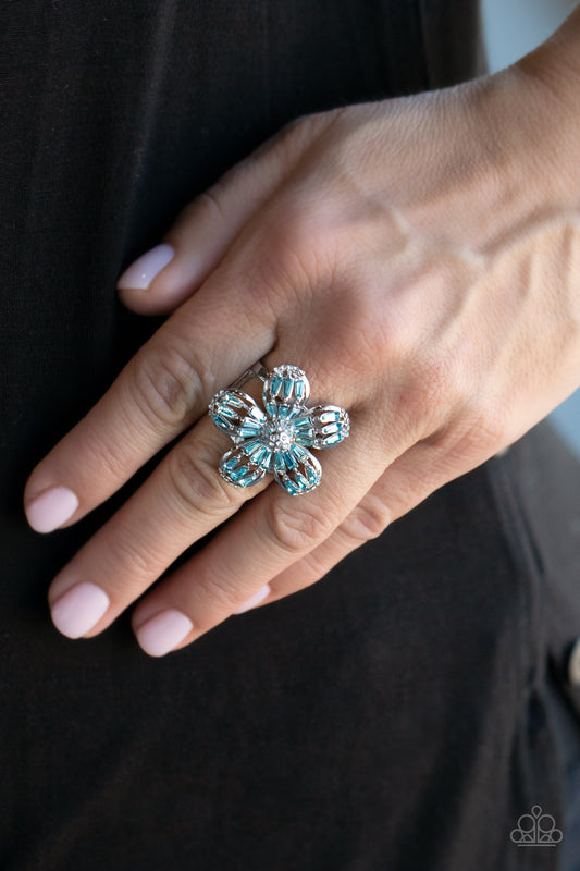 Botanical Ballroom Blue Ring - Paparazzi Accessories  Blue emerald-style rhinestones adorn the silver petals of a blooming flower featuring a white rhinestone encrusted beaded center. The tips of the colorful petals are dusted in dainty white rhinestones, adding extra shimmer to the sparkly centerpiece. Features a stretchy band for a flexible fit.  All Paparazzi Accessories are lead free and nickel free!  Sold as one individual ring.
