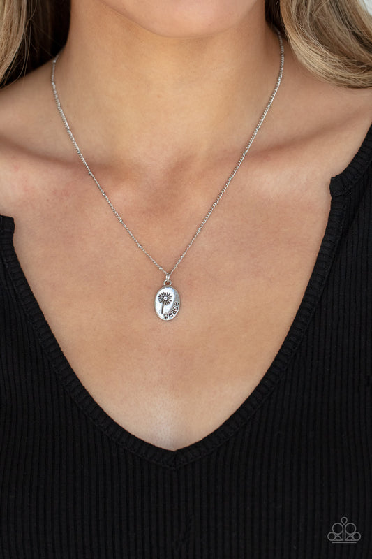 Be The Peace You Seek Silver Necklace - Paparazzi Accessories  Featuring a blooming dandelion, a simple silver disc is stamped in the word, "Peace," creating a whimsical pendant below the collar. Features an adjustable clasp closure.  All Paparazzi Accessories are lead free and nickel free!  Sold as one individual necklace. Includes one pair of matching earrings.