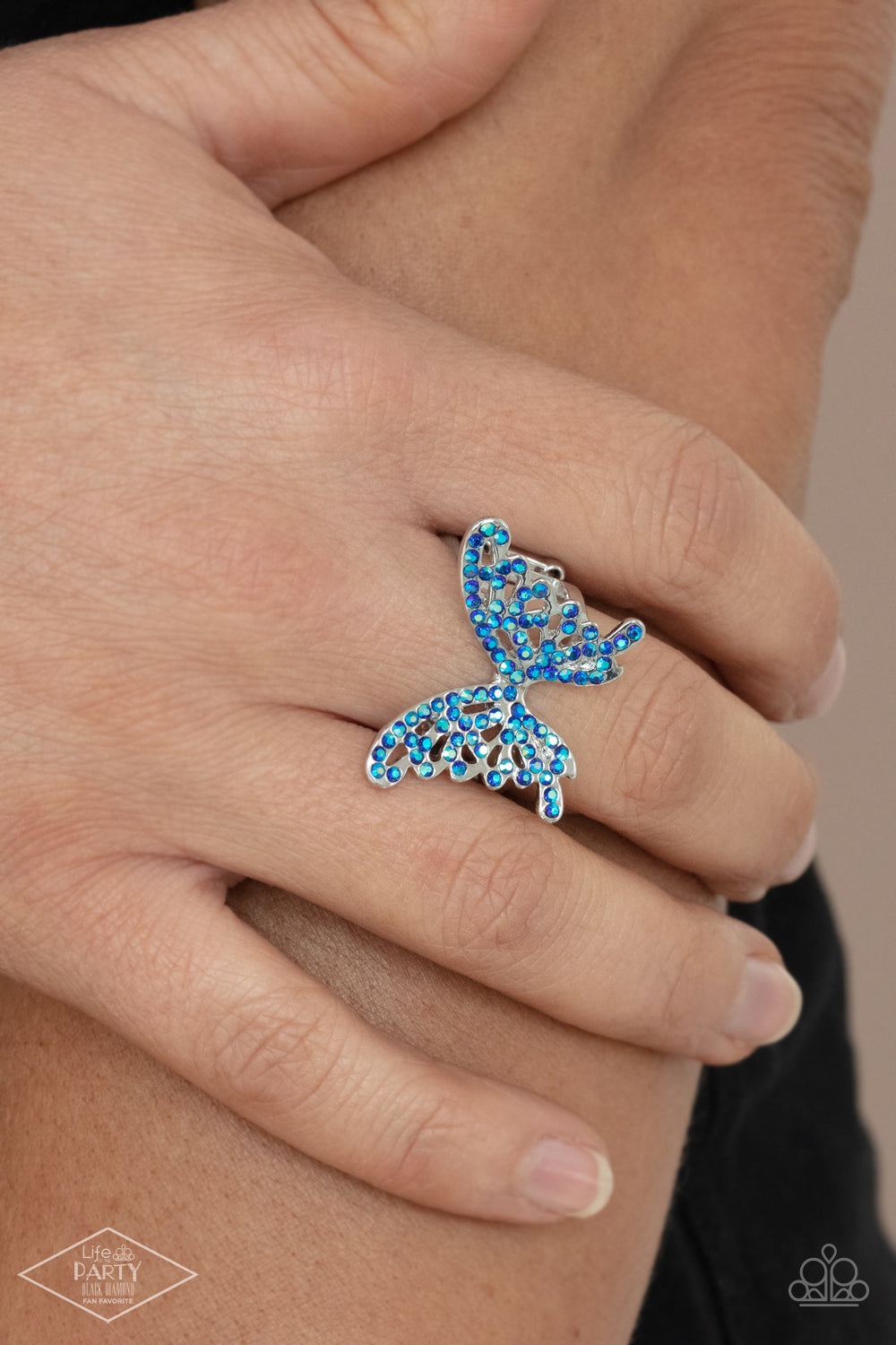 Butterfly Orchard Blue Ring - Paparazzi Accessories  Featuring an iridescent shimmer, dainty blue rhinestones adorn a silver butterfly atop the finger for an enchanted fashion. Features a stretchy band for a flexible fit.  Sold as one individual ring. This Fan Favorite is back in the spotlight at the request of our 2021 Life of the Party member with Black Diamond Access, Paula H.