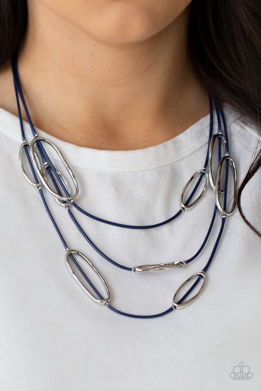 Check Your CORD-inates Blue Necklace - Paparazzi Accessories  An asymmetrical collection of hammered silver ovals are fitted in place along three rows of shiny blue cords, creating an edgy display below the collar. Features an adjustable clasp closure.  Sold as one individual necklace. Includes one pair of matching earrings.