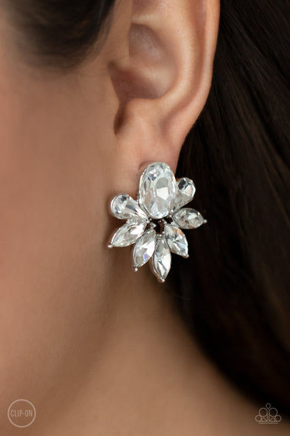 Fearless Finesse White Clip-On Earring - Paparazzi Accessories  A glassy collection of white teardrop and marquise cut rhinestones fan out from the bottom of an oval white gem, creating a majestic centerpiece. Earring attaches to a standard clip-on earring.  All Paparazzi Accessories are lead free and nickel free!  Sold as one pair of clip-on earrings.