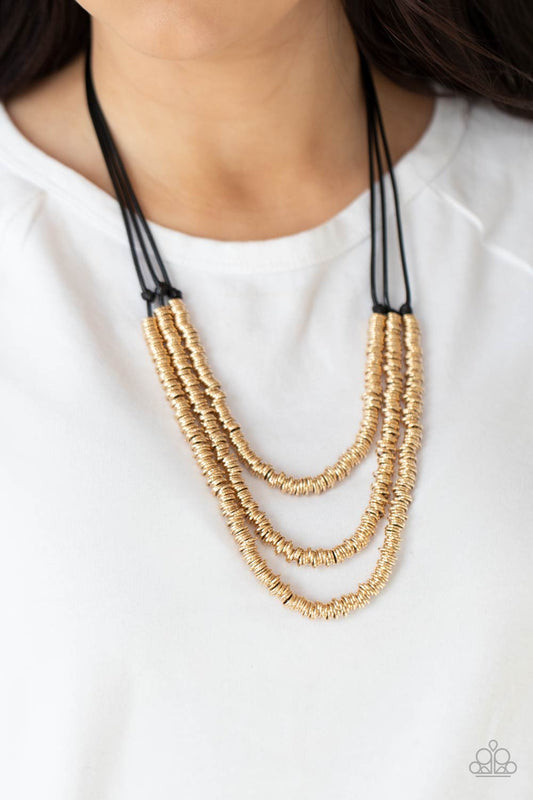 RING to Reason Gold Necklace - Paparazzi Accessories. A seemingly infinite collection of dainty gold rings are knotted in place along three black cords, creating edgy layers across the chest. Features an adjustable clasp closure.  All Paparazzi Accessories are lead free and nickel free!  Sold as one individual necklace. Includes one pair of matching earrings.