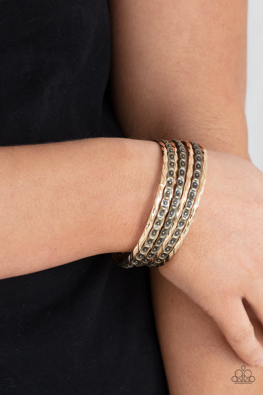 Back-To-Back Stacks Multi Bracelet - Paparazzi Accessories  Embossed in slanted ribbons of textured and studded hammered patterns, trios of mismatched brass and gold bangles stack across the wrist for an intense industrial vibe.  Sold as one set of six bracelets.