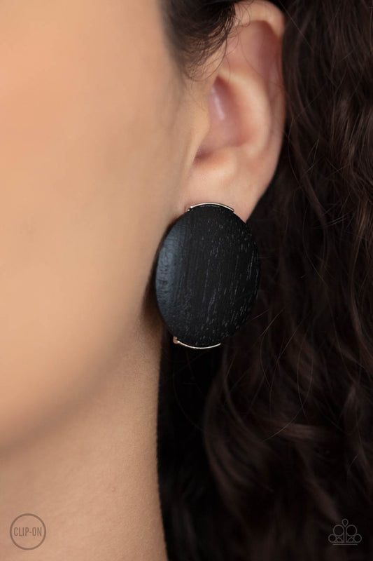 WOODWORK It Black Clip-On Earring - Paparazzi Accessories  An oversized black wooden disc is fitting in place between a silver frame, creating an earthy effect. Earring attaches to a standard clip-on fitting.  All Paparazzi Accessories are lead free and nickel free!  Sold as one pair of clip-on earrings.