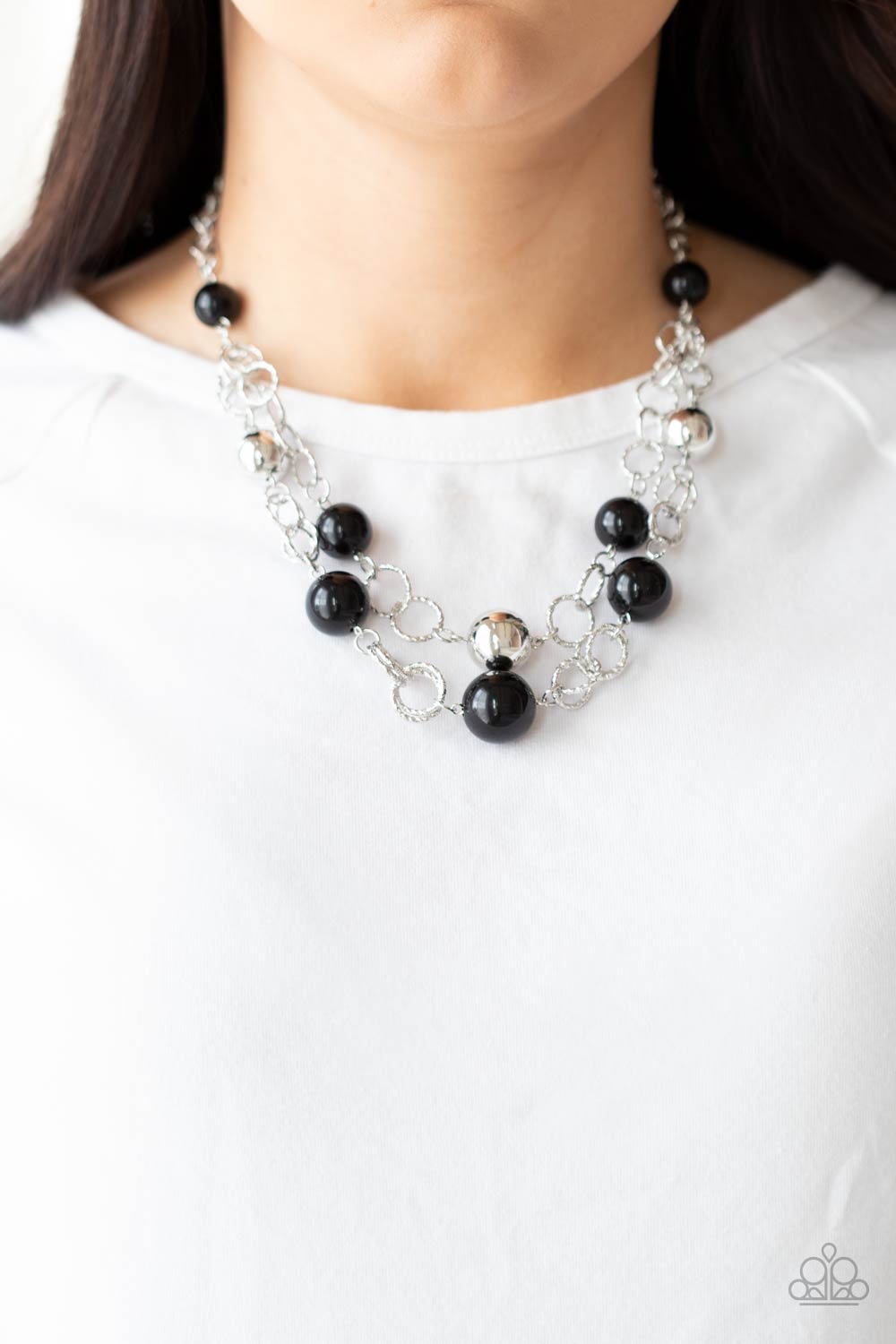 New Age Knockout Black Necklace - Paparazzi Accessories  Sections of oversized textured silver links, polished black and shiny silver beads haphazardly connect into two timeless layers below the collar, creating a dramatically refined display. Features an adjustable clasp closure.  Sold as one individual necklace. Includes one pair of matching earrings.