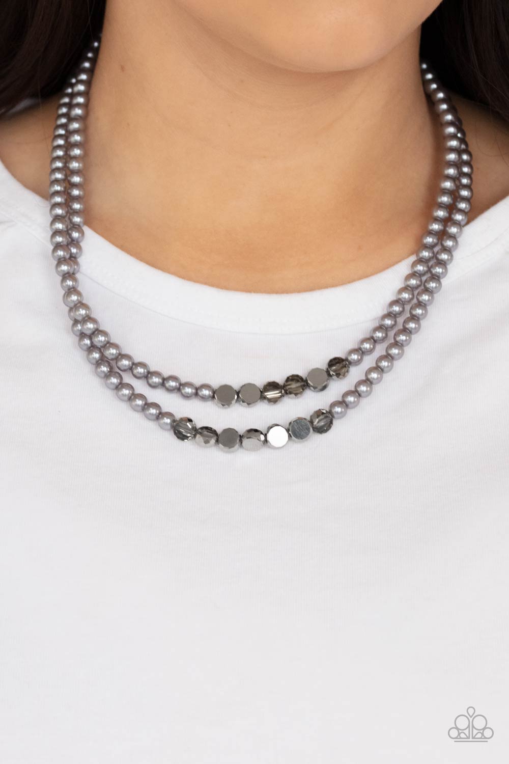 Poshly Petite Silver Necklace - Paparazzi Accessories.  A posh collection of pearly gray beads, accented by sections of flat, faceted metallic beads, is threaded along invisible wires, creating sophisticated layers that fall below the collar. Features an adjustable clasp closure.  ﻿All Paparazzi Accessories are lead free and nickel free!  Sold as one individual necklace. Includes one pair of matching earrings.
