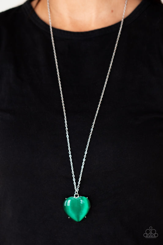 Warmhearted Glow Green Heart Necklace - Paparazzi Accessories  An oversized Mint cat's eye stone frame swings from the bottom of a lengthened silver chain, creating a flirtatious pendant. Features an adjustable clasp closure.  All Paparazzi Accessories are lead free and nickel free!  Sold as one individual necklace. Includes one pair of matching earrings.