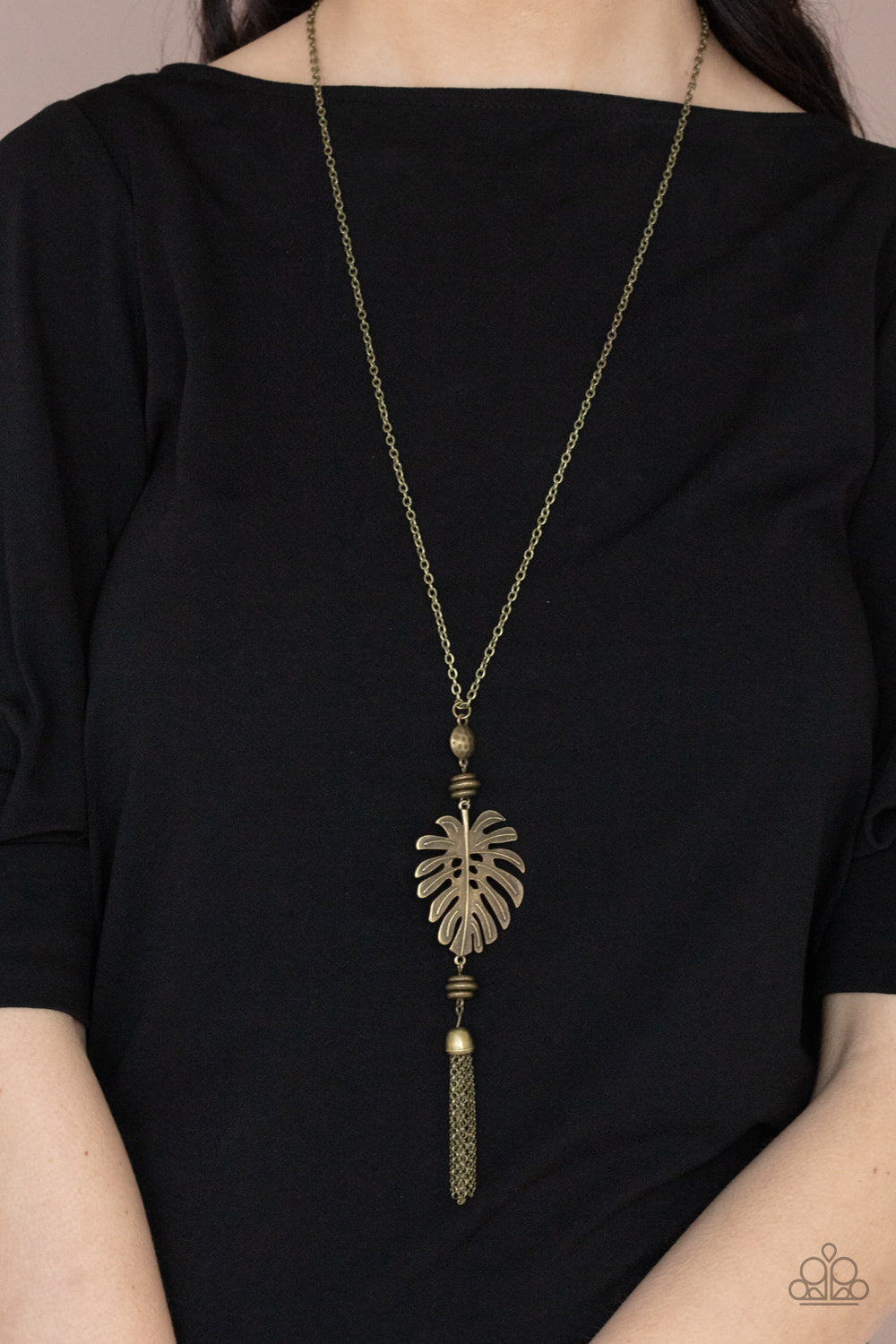 Palm Promenade Brass Necklace - Paparazzi Accessories  Infused with brass beaded accents, a lifelike brass palm leaf frame attaches to the bottom of a rustic brass chain. An antiqued brass chain tassel swings from the bottom, adding flirtatious movement to the summery statement piece. Features an adjustable clasp closure.  All Paparazzi Accessories are lead free and nickel free!  Sold as one individual necklace. Includes one pair of matching earrings.