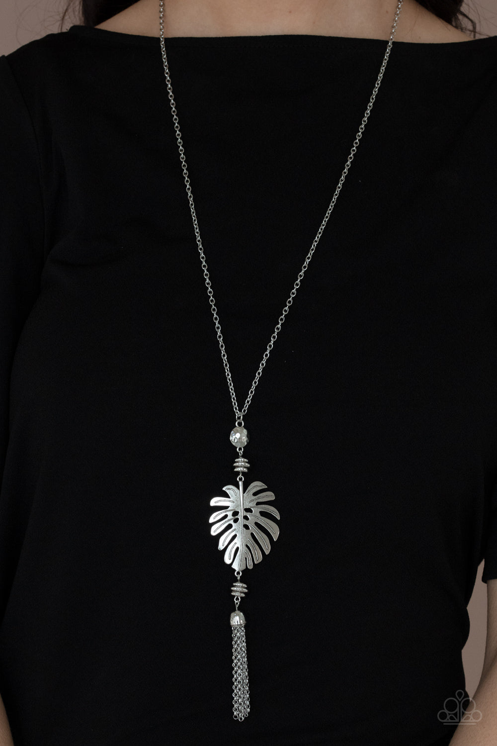 Palm Promenade Silver Necklace - Paparazzi Accessories  Infused with silver beaded accents, a lifelike silver palm leaf frame attaches to the bottom of a shimmery silver chain. A silver chain tassel swings from the bottom, adding flirtatious movement to the summery statement piece. Features an adjustable clasp closure.  Sold as one individual necklace. Includes one pair of matching earrings.