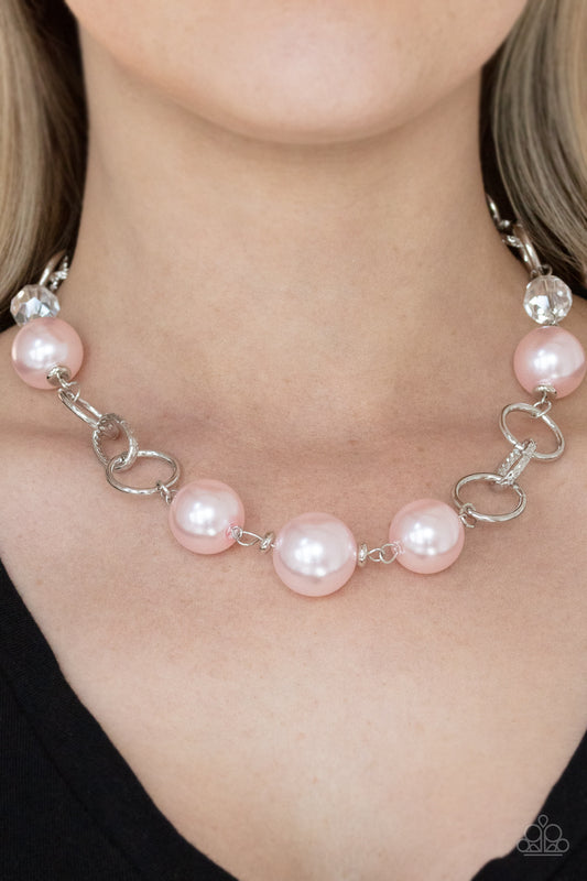 New Age Novelty Pink Pearl Necklace - Paparazzi Accessories  Sections of bold silver links, oversized pink pearls, and glassy crystal-like beads haphazardly connect below the collar, creating a dramatic display. Features an adjustable clasp closure.  Sold as one individual necklace. Includes one pair of matching earrings.
