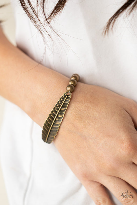 Featherlight Fashion Brass Bracelet - Paparazzi Accessories. Infused with a lifelike brass feather frame, a row of rustic brass beads are threaded along stretchy bands around the wrist for a seasonal fashion.  All Paparazzi Accessories are lead free and nickel free!  Sold as one individual bracelet.