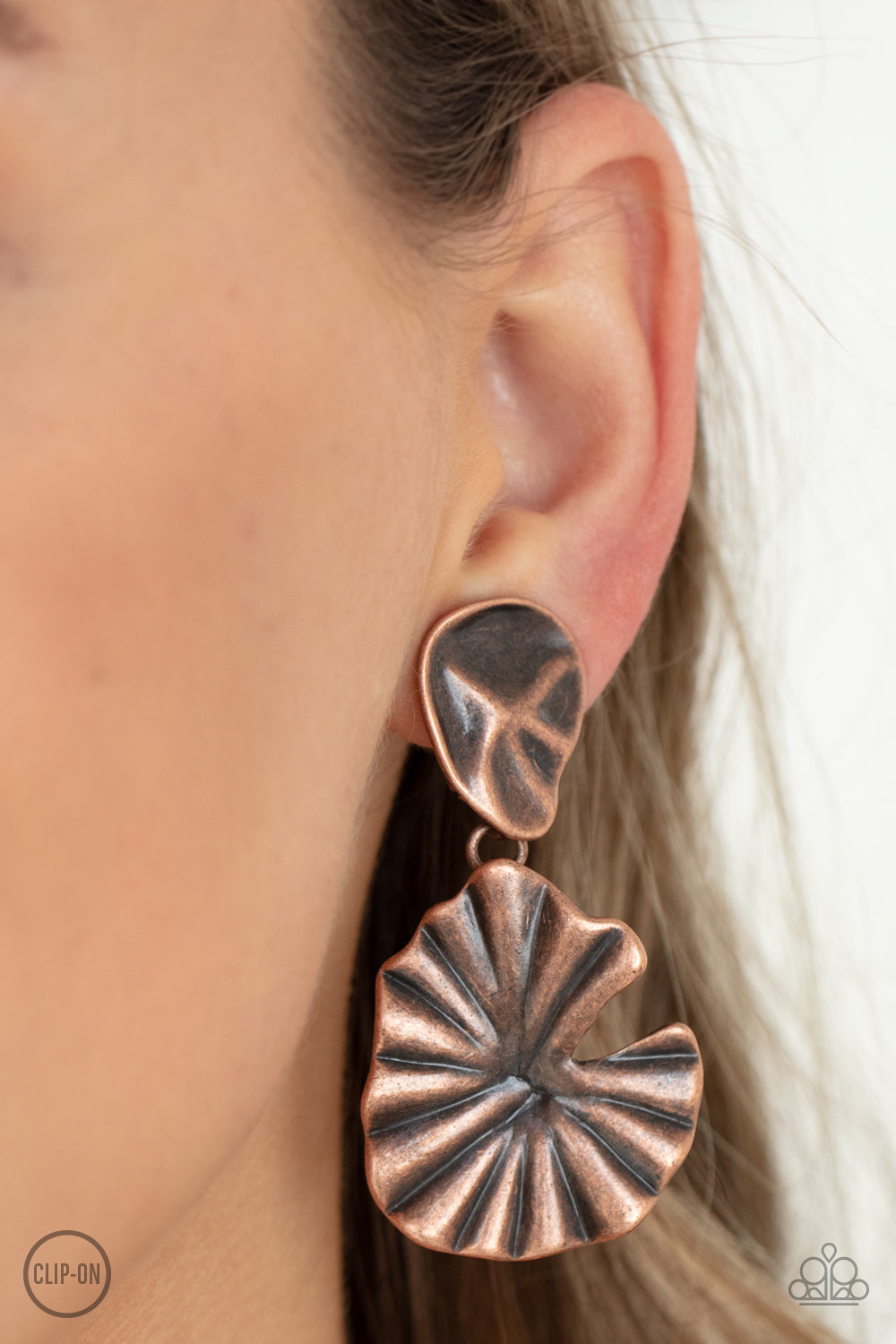 Empress Of The Amazon Copper Clip-On Earring - Paparazzi Accessories  A pair of antiqued copper jungle leaves - one small, one large - fan out and dangle from the ear for a powerful Amazonian vibe. Earring attaches to a standard clip-on fitting.  Sold as one pair of clip-on earrings.