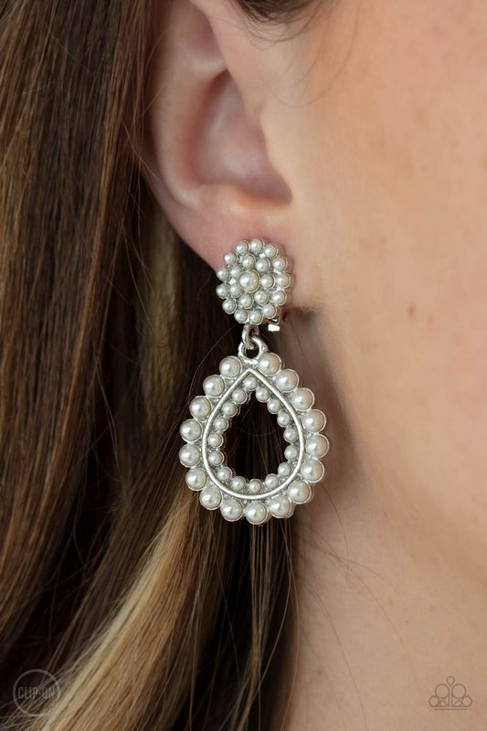 Discerning Droplets White Clip-On Earring - Paparazzi Accessories  Droplets of pearls dot the surface of a silver teardrop frame that suspends from a round pearl encrusted disc for a classic finish. Earring attaches to a standard clip-on fitting.  All Paparazzi Accessories are lead free and nickel free!  Sold as one pair of clip-on earrings.