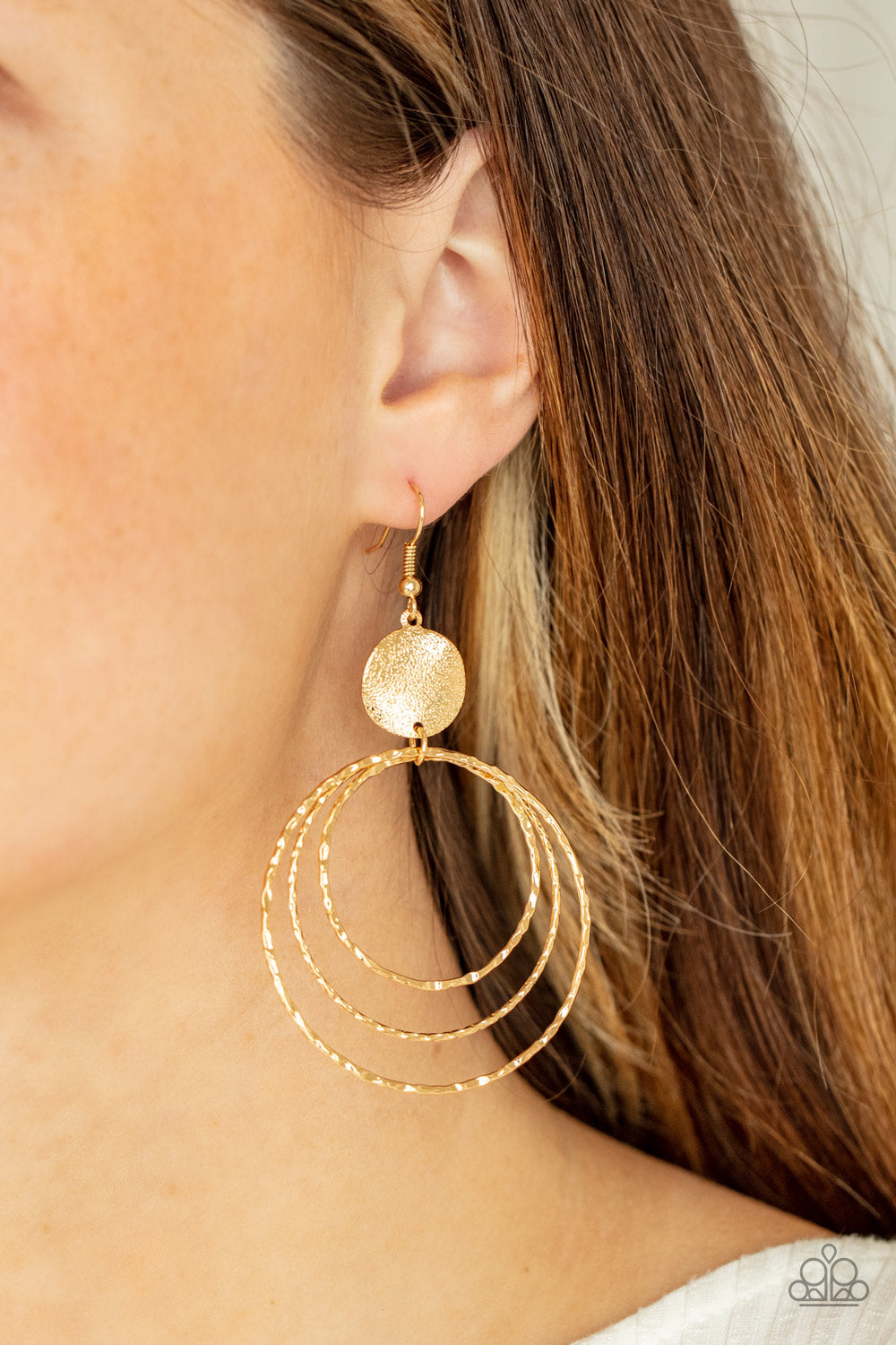 Universal Rehearsal Gold Earring - Paparazzi Accessories  A shimmery wavy gold disc links atop a collection of three delicately hammered gold rings in concentric sizes for an out-of-this-world finish. Earring attaches to a standard fishhook fitting.  All Paparazzi Accessories are lead free and nickel free!  Sold as one pair of earrings.