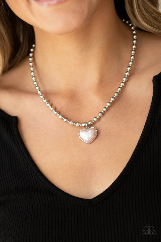 Heart Full of Fancy Pink Necklace - Paparazzi Accessories  Featuring a pearly pink center, a charming heart pendant suspends from a strand of silver beads below the collar for a romantic flair. Features an adjustable clasp closure.  All Paparazzi Accessories are lead free and nickel free!  Sold as one individual necklace. Includes one pair of matching earrings.