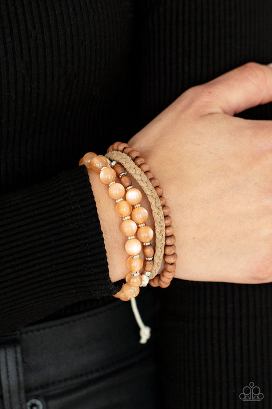 Down HOMESPUN Orange Urban Bracelet - Paparazzi Accessories  Strands of glassy orange cat's eye beads stand out in an earthy collection of wooden beads and braided twine, giving a polished flair to the natural homespun look as it stacks up the wrist. Features an adjustable sliding knot closure.  All Paparazzi Accessories are lead free and nickel free!  Sold as one individual bracelet.