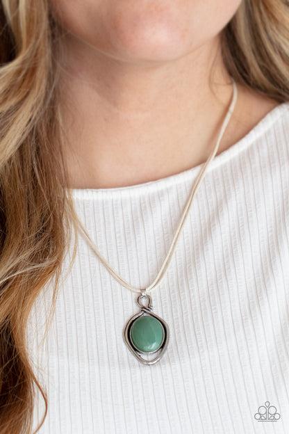 Desert Mystery Green Necklace - Paparazzi Accessories  An oversized jade stone is pressed into a silver oval frame, outlined with an unexpected irregular shaped frame. The eye-catching pendant suspends from a double strand of white cord below the collar for a mysterious finish. Features an adjustable clasp closure.  All Paparazzi Accessories are lead free and nickel free!  Sold as one individual necklace. Includes one pair of matching earrings.