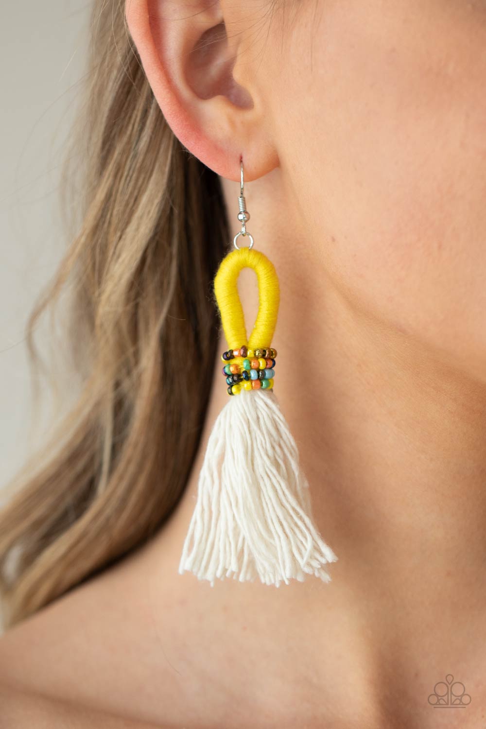 The Dustup Yellow Earring - Paparazzi Accessories  A tassel of soft white cotton fans out under rows of brightly colored seed beads. Anchored by a loop of vibrant yellow floss, the eye-catching style swings from the ear for a show-stopping statement. Earring attaches to a standard fishhook fitting.  All Paparazzi Accessories are lead free and nickel free!  Sold as one pair of earrings.