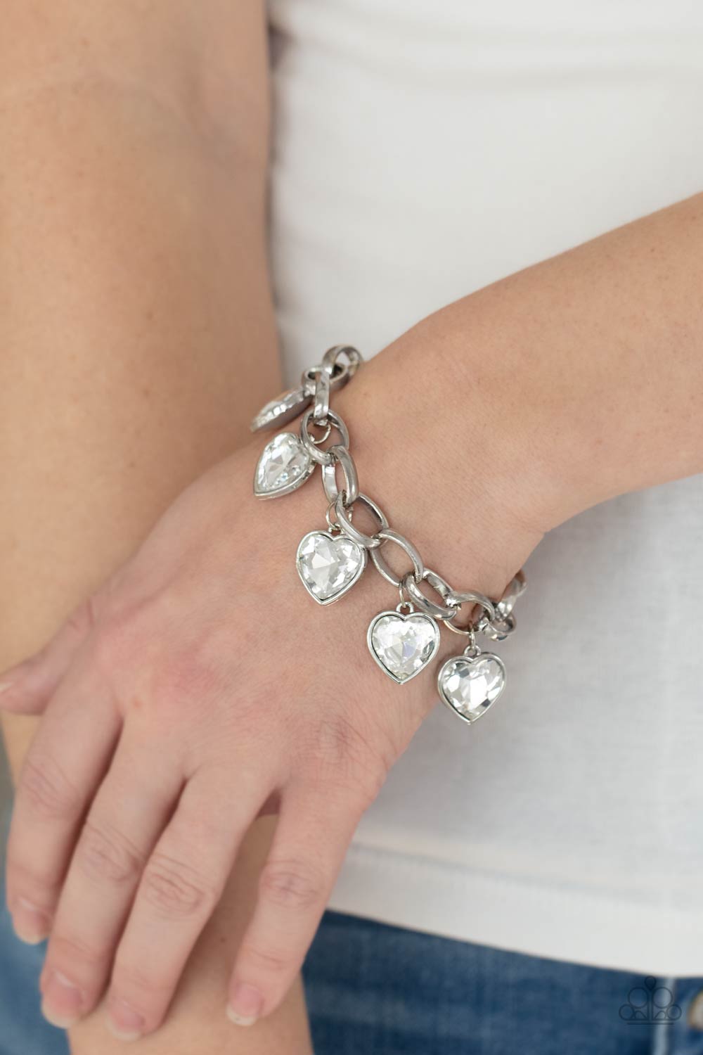 Candy Heart Charmer White Bracelet - Paparazzi Accessories  White heart-shaped gems are encased in sleek silver frames that swing from an oversized silver chain, creating a sparkly fringe around the wrist. Features an adjustable clasp closure.  All Paparazzi Accessories are lead free and nickel free!   Sold as one individual bracelet.