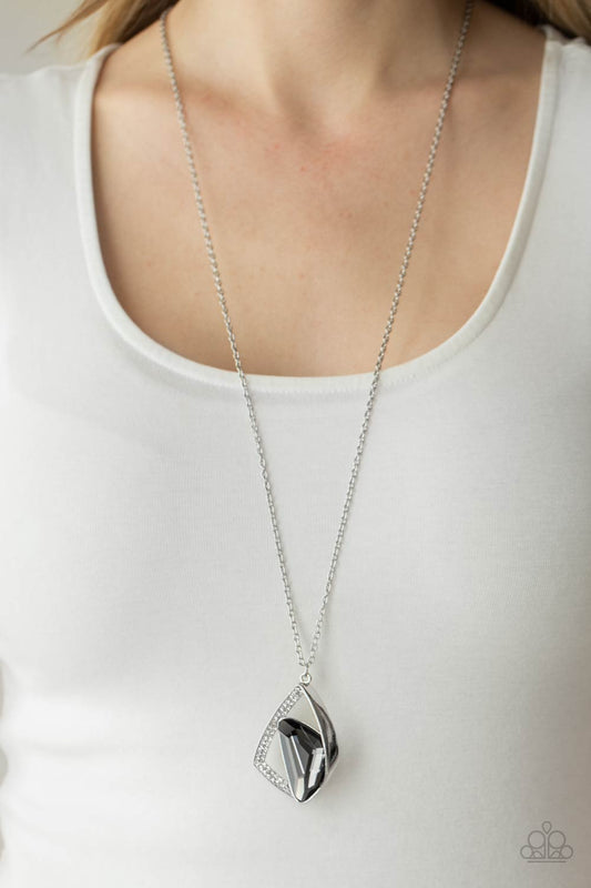 Galactic Wonder Silver Necklace - Paparazzi Accessories  A triangular smoky gem is nestled inside folds of a shiny silver frame and white rhinestone encrusted silver ribbons, creating an asymmetrical pendant at the bottom of a lengthened silver chain. Features an adjustable clasp closure.  ﻿All Paparazzi Accessories are lead free and nickel free!  Sold as one individual necklace. Includes one pair of matching earrings.