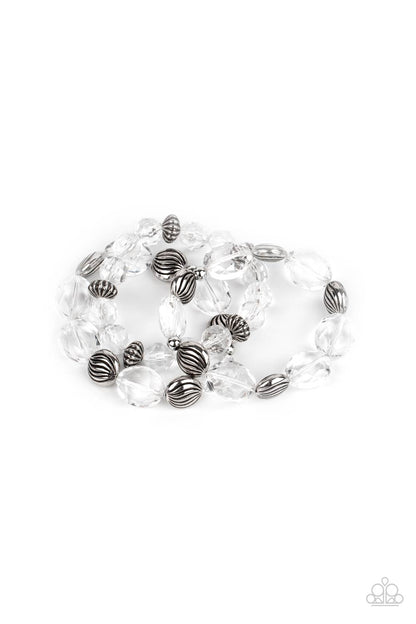 Crystal Charisma White Bracelet - Paparazzi Accessories A mismatched collection of sparkly white crystal-like beads and textured silver accents are threaded along stretchy bands around the wrist, creating glamorous layers.  ﻿All Paparazzi Accessories are lead free and nickel free!  Sold as one set of three bracelets.