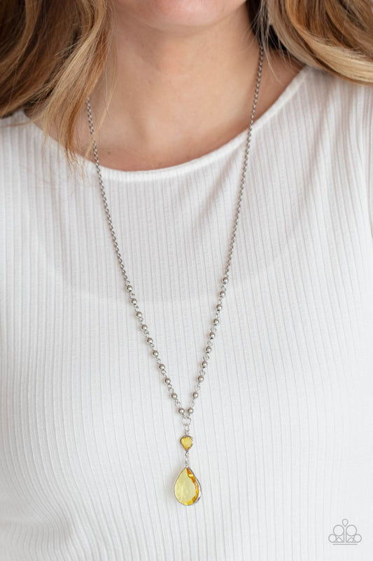 Titanic Splendor Yellow Necklace - Paparazzi Accessories  A magnificent Primrose teardrop gem steals the show as it dangles brilliantly from a lengthened silver chain. A small heart-shaped Primrose gem and shiny round beads accentuate the majestic look. Features an adjustable clasp closure.  All Paparazzi Accessories are lead free and nickel free!  Sold as one individual necklace. Includes one pair of matching earrings.