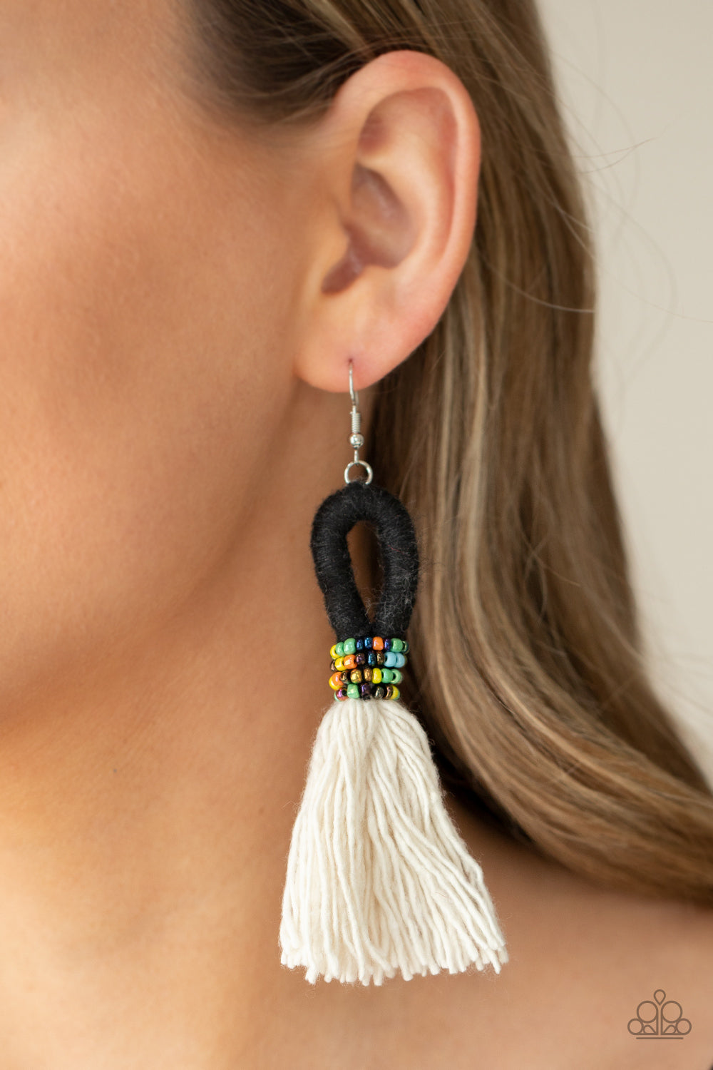 The Dustup Black Earring - Paparazzi Accessories  A tassel of soft white cotton fans out under rows of brightly colored seed beads. Anchored by a loop of jet black floss, the eye-catching style swings from the ear for a show-stopping statement. Earring attaches to a standard fishhook fitting.  All Paparazzi Accessories are lead free and nickel free!  Sold as one pair of earrings.
