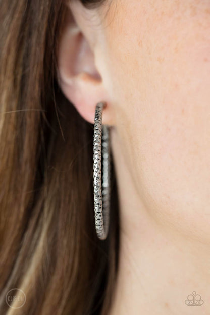 Subtly Sassy Silver Clip-On Earring - Paparazzi Accessories  An oversized silver hoop featuring a porous-like texture sends off a subtle shimmer as it wraps around the ear. Earring attaches to a standard clip-on fitting. Hoop measures approximately 2" in diameter.  Sold as one pair of clip-on earrings.