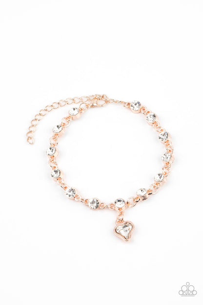 Sweet Sixteen Rose Gold Bracelet - Paparazzi Accessories  Brilliant white rhinestones in rose gold settings are linked together and accented with a charming white rhinestone heart that dangles sweetly from the wrist. Features an adjustable clasp closure.  All Paparazzi Accessories are lead free and nickel free!  Sold as one individual bracelet.