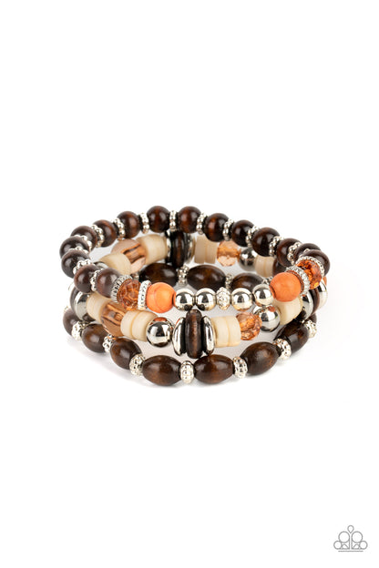 Belongs In The Wild Multi Bracelet - Paparazzi Accessories  A mismatched collection of brown wooden beads, silver accents, orange stones, Buttercream discs, and glassy Desert Mist beads are threaded along stretchy bands, creating colorful layers around the wrist.  Sold as one set of three bracelets.