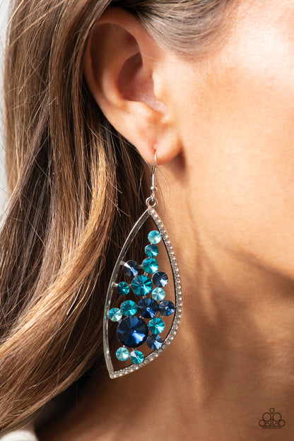 Sweetly Effervescent Blue Earring - Paparazzi Accessories  A bubbly collection of light to dark blue rhinestones coalesce inside an asymmetrical silver frame. One side of the frame is encrusted in glassy white rhinestones, adding a refined flair to the bubbly lure. Earring attaches to a standard fishhook fitting.  All Paparazzi Accessories are lead free and nickel free!  Sold as one pair of earrings.