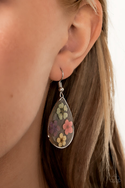 Perennial Prairie Multi Earring - Paparazzi Accessories   Dainty green, pink, purple, and yellow flowers are encased in a glassy teardrop, creating a whimsical frame. Earring attaches to a standard fishhook fitting.  All Paparazzi Accessories are lead free and nickel free!  Sold as one pair of earrings.