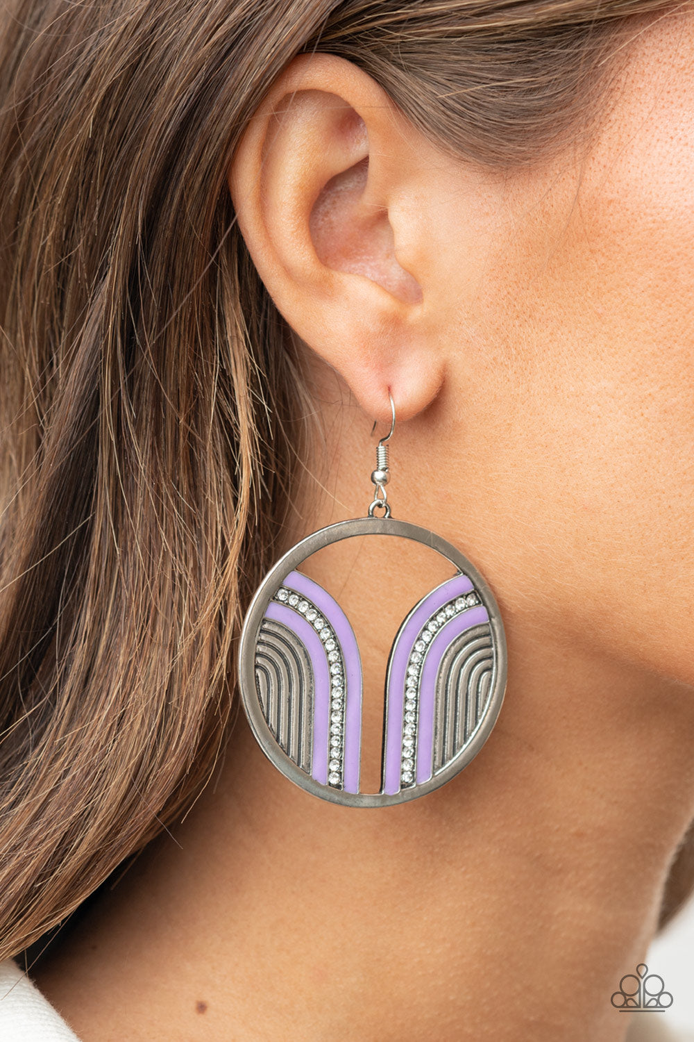 Delightfully Deco Purple Earring - Paparazzi Accessories.  Infused with a glittery row of white rhinestones, shiny purple arcs curve into juxtaposed frames inside a classic silver hoop, creating a colorful art deco inspired centerpiece. Earring attaches to a standard fishhook fitting.  ﻿﻿﻿All Paparazzi Accessories are lead free and nickel free!  Sold as one pair of earrings.
