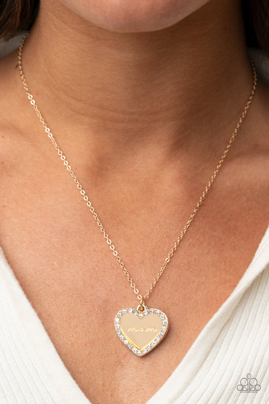 The Real Boss Gold Necklace - Paparazzi Accessories  Infused with a glassy white rhinestone encrusted gold heart, a gold heart shaped pendant is stamped in the word, "Mom," as it swings below the collar, creating a sparkly sentimental statement piece. Features an adjustable clasp closure.  Sold as one individual necklace. Includes one pair of matching earrings.