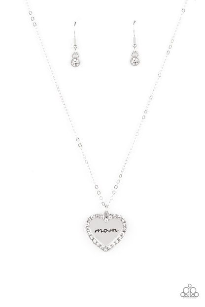 The Real Boss White Necklace - Paparazzi Accessories  Infused with a glassy white rhinestone encrusted silver heart, a silver heart shaped pendant is stamped in the word, "Mom," as it swings below the collar, creating a sparkly sentimental statement piece. Features an adjustable clasp closure.  Sold as one individual necklace. Includes one pair of matching earrings.