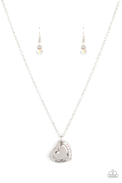 Happily Heartwarming White Necklace - Paparazzi Accessories  Stamped in the word, "Mother," an embossed heart pendant is encrusted in a row of white and iridescent rhinestones, creating a sparkly sentimental centerpiece below the collar. Features an adjustable clasp closure.  Sold as one individual necklace. Includes one pair of matching earrings.