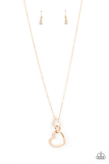 Grandma Glow Gold Necklace - Paparazzi Accessories  A gold heart engraved with the word "Grandma," dangles from two smaller hearts at the bottom of a lengthened shimmery gold chain. The first heart is accented with sparkly white rhinestones creating an affectionately sentimental pendant. Features an adjustable clasp closure.  Sold as one individual necklace. Includes one pair of matching earrings.