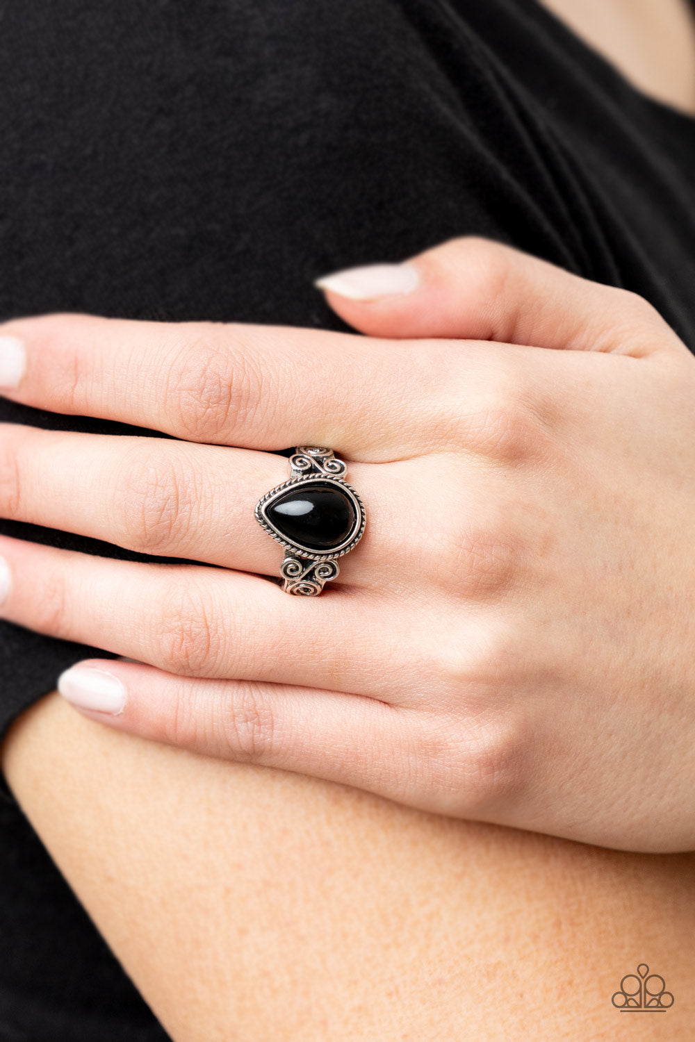 Dreamy Droplets Black Ring - Paparazzi Accessories  A shining black teardrop bead is pressed into a delicately braided silver frame. Featuring silver filigree scrolls, an airy band creates a dreamy backdrop for the centerpiece as it sits atop the finger. Features a dainty stretchy band for a flexible fit.  Sold as one individual ring.