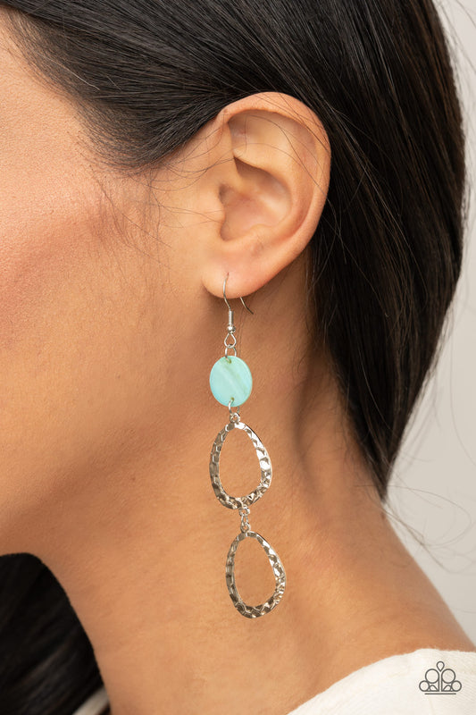 Surfside Shimmer Blue Earring - Paparazzi Accessories.  A pearly blue shell disc anchors to two shiny hammered silver asymmetrical hoops as they dangle from the ear creating a dazzling lure. Earring attaches to a standard fishhook fitting.  ﻿All Paparazzi Accessories are lead free and nickel free!  Sold as one pair of earrings.