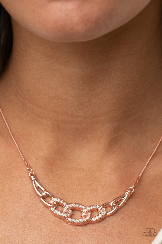 KNOT In Love Copper Necklace - Paparazzi Accessories  Shiny copper links, encrusted with brilliant dainty white rhinestones, connect into a glamorous centerpiece below the collar. Features an adjustable clasp closure.  Sold as one individual necklace. Includes one pair of matching earrings.