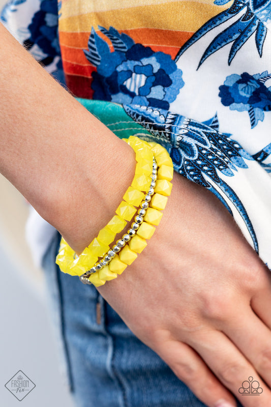 Vacay Vagabond Yellow Bracelet - Paparazzi Accessories  Infused with a strand of round and faceted silver beads, faceted rows of solid and opaque Illuminating cube beads are threaded along stretchy bands, wrapping around the wrist for an edgy pop of color.  All Paparazzi Accessories are lead free and nickel free!  Sold as one set of three bracelets.