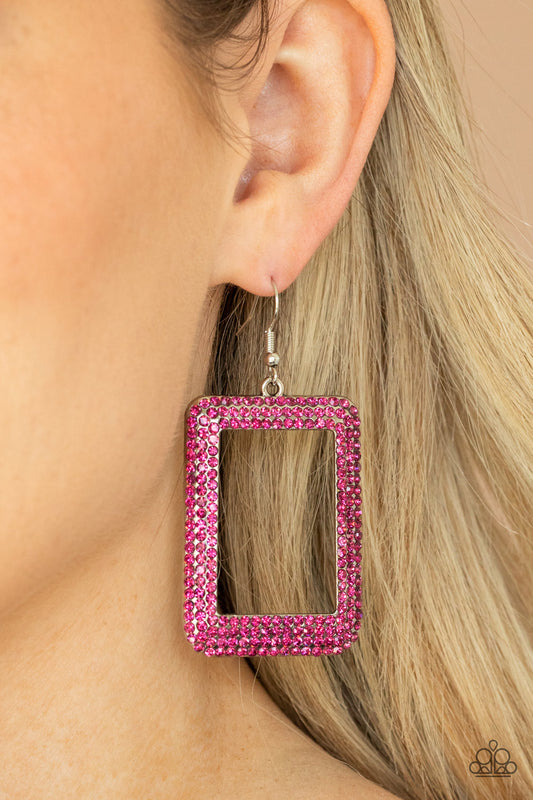 World FRAME-ous Pink Earring - Paparazzi Accessories  Bordered in rows of glittery pink rhinestones, an oversized silver rectangular frame swings from the ear for a fashionable finish. Earring attaches to a standard fishhook fitting.  All Paparazzi Accessories are lead free and nickel free!  Sold as one pair of earrings.