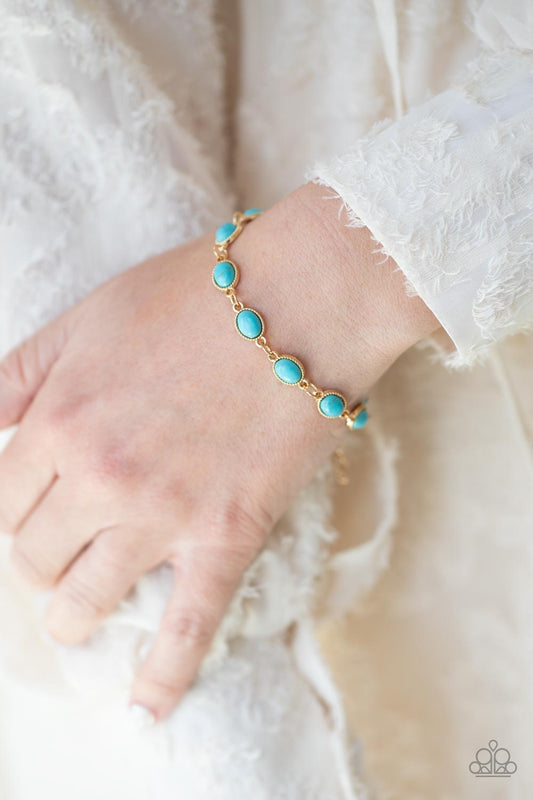 Desert Day Trip Blue Bracelet - Paparazzi Accessories  Encased in studded gold frames, oval turquoise stones delicately connect around the wrist for a seasonal flair. Features an adjustable clasp closure.  Sold as one individual bracelet.