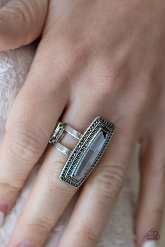 Luminary Luster Silver Ring - Paparazzi Accessories  An elongated smoky gem is pressed into the center of a studded silver frame atop layered silver bands, creating a stellar centerpiece atop the finger. Features a stretchy band for a flexible fit.  Sold as one individual ring.