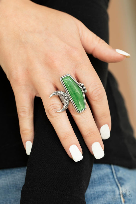 Cosmic Karma Green Ring - Paparazzi Accessories  Encased in a raised silver fitting, a geometric jade stone is flank by a decorative row of silver studs and an ornate half moon frame for a seasonal statement. The oversized frame is attentional, creating the illusion of multiple rings. Features a stretchy band for a flexible fit.  All Paparazzi Accessories are lead free and nickel free!   Sold as one individual ring.