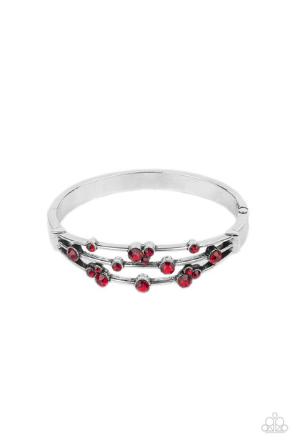 Cosmic Candescence Red Bracelet - Paparazzi Accessories  A smattering of fiery red rhinestones adorn three silver bars that coalesce into a versatile silver cuff-like bangle around the wrist. Features a hinged closure.  All Paparazzi Accessories are lead free and nickel free!  Sold as one individual bracelet.