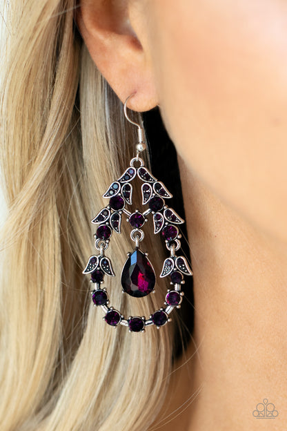 Garden Decorum - Purple Item #P5RE-PRXX-163XX A solitaire purple teardrop rhinestone swings from the top of an ornately hinged teardrop frame adorned in purple rhinestone dotted leafy silver frames, creating a glamorous centerpiece. Earring attaches to a standard fishhook fitting.  Sold as one pair of earrings.