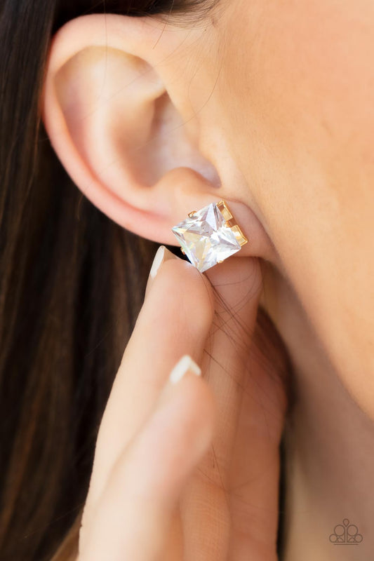 Times Square Timeless Gold Earring - Paparazzi Accessories  A stunning oversized square rhinestone, set in a classic gold pronged fitting, makes a show-stopping impact as it shines brilliantly and draws attention up to the face. Earring attaches to a standard post fitting.  Sold as one pair of post earrings.