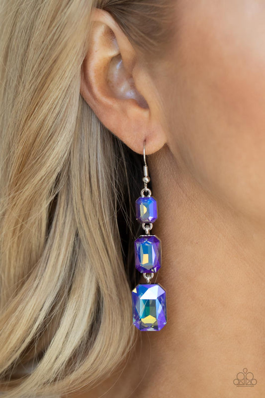Cosmic Red Carpet Blue Earring - Paparazzi Accessories  Featuring a dazzling blue and gold UV shimmer, a trio of emerald-cut gems in graduating sizes is linked one below the other for a dramatic red carpet finish. Earring attaches to a standard fishhook fitting.  Sold as one pair of earrings.